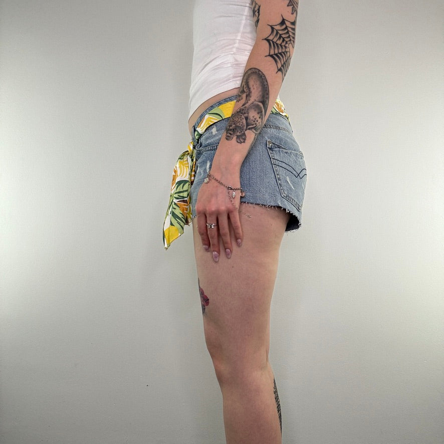 Y2K low rise raw hem mini denim shorts with sunflower tie belt